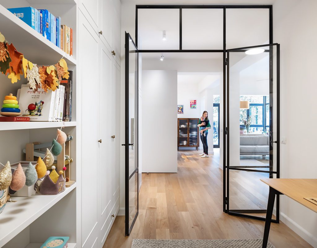 White shelves with toys beside black glass doors