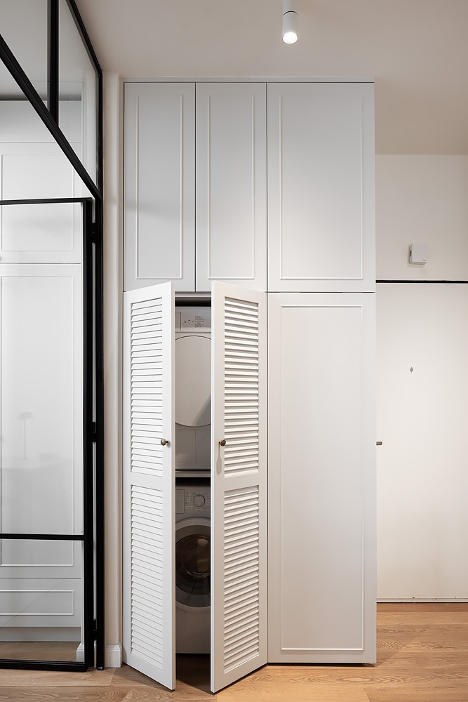 White laundry cupboard with louvred doors open