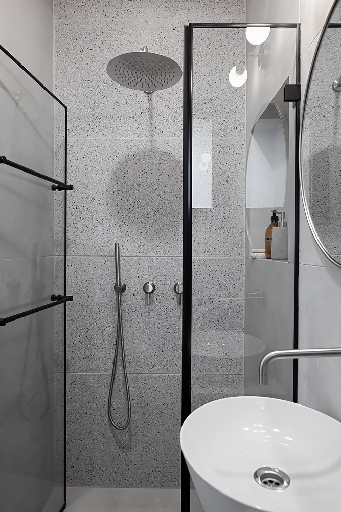 Terrazzo shower with a black-framed glass screen