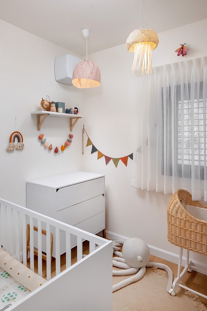 White nursery with a cot and a wicker crib