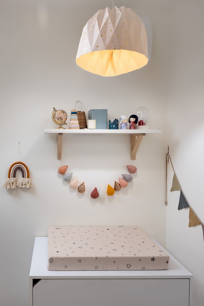 Changing table and a folded paper lamp in the nursery
