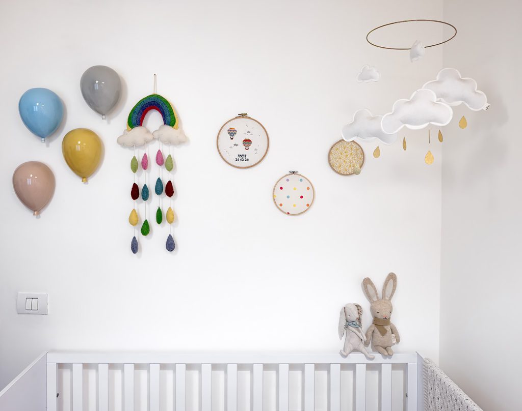 Colourful decorations on the nursery wall above the cot