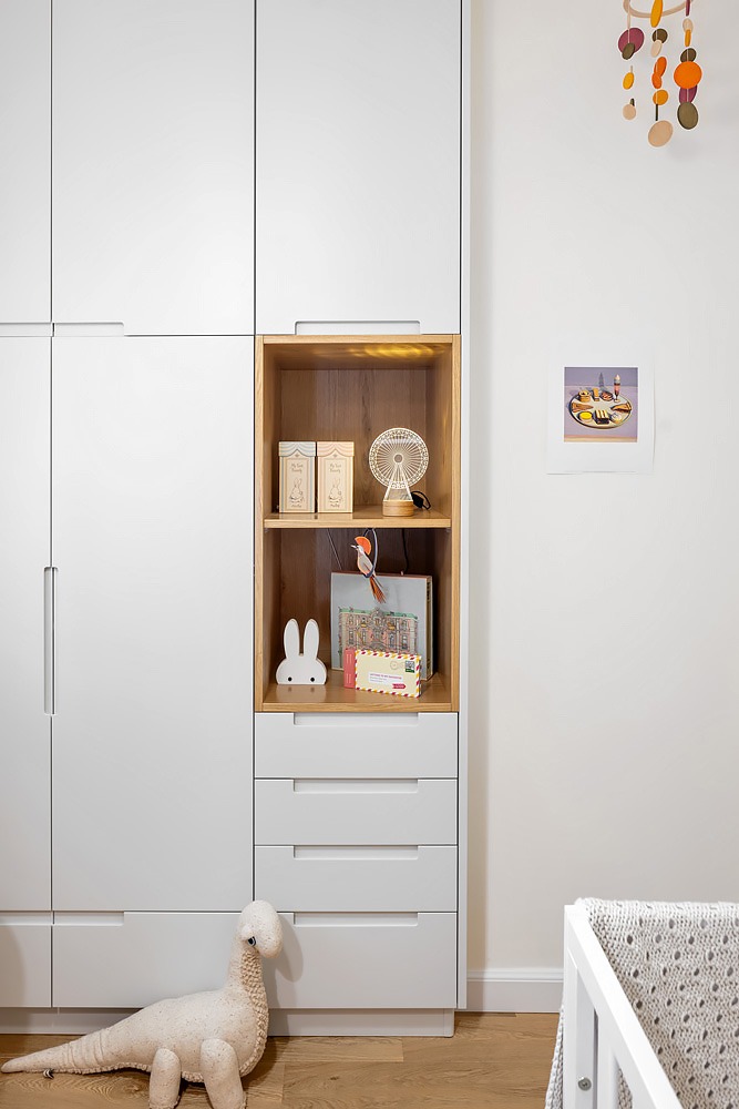 White wardrobe with a wooden niche in a baby's room