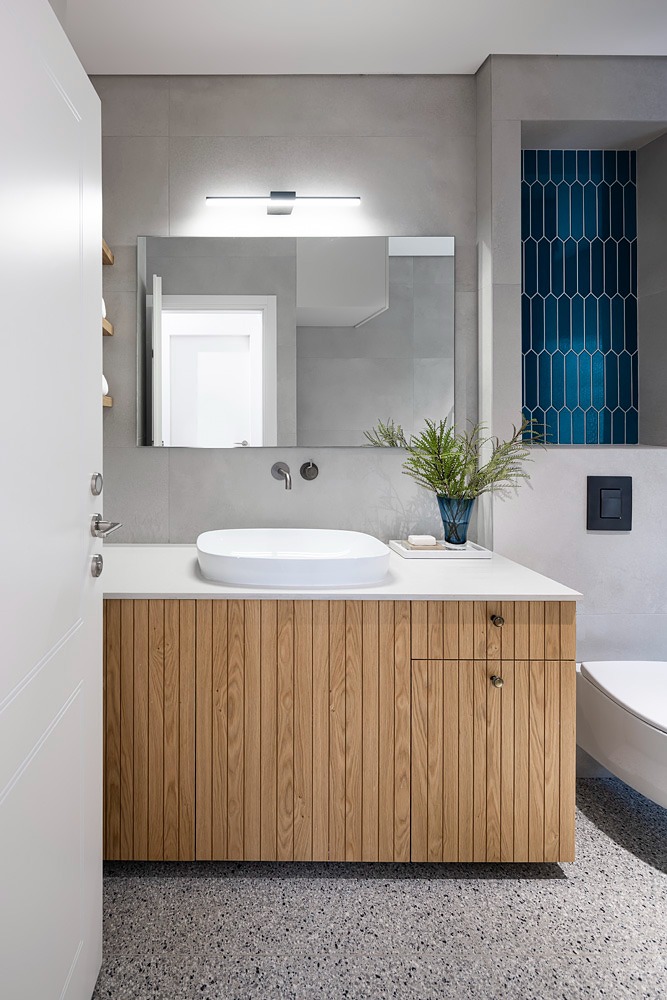Fluted wooden vanity with a white countertop basin