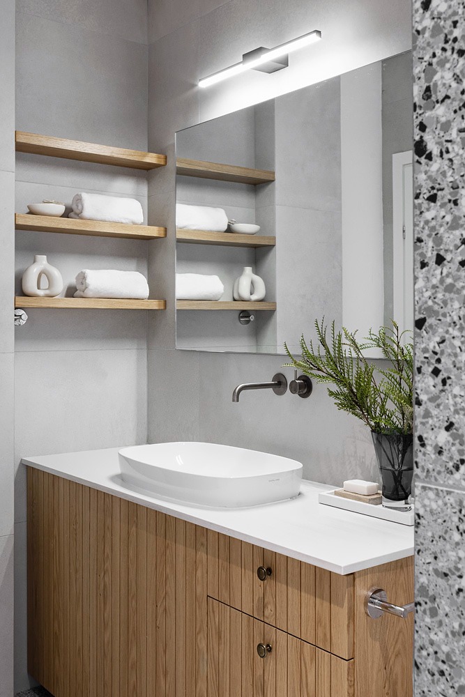 Open wooden towel shelves above the vanity