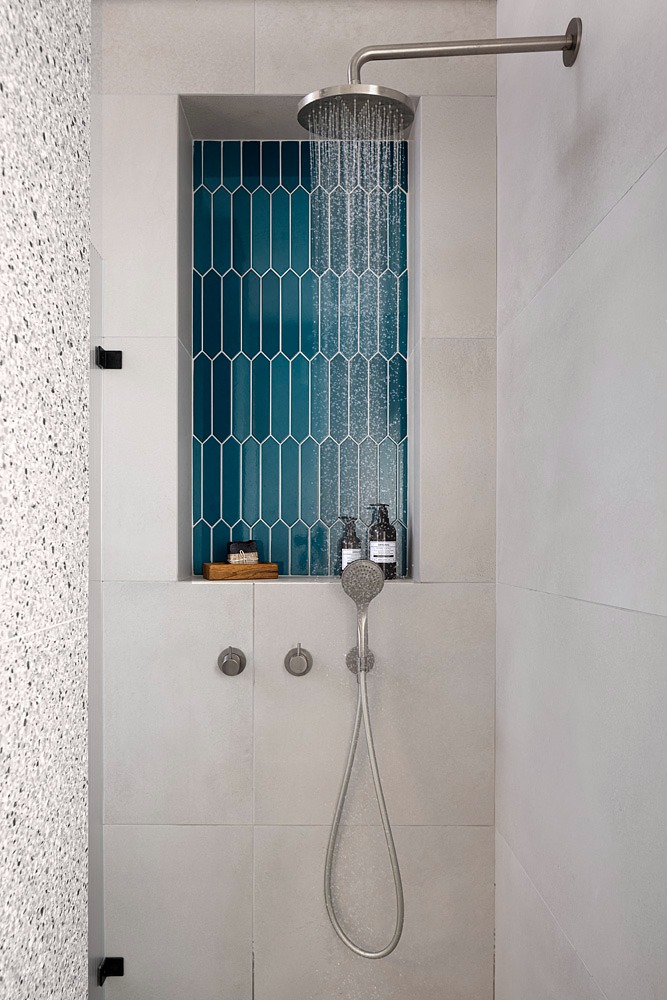 Shower with a niche of teal tiles