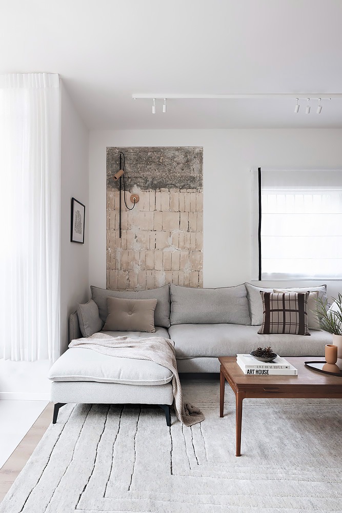 Grey corner sofa below a textured artwork