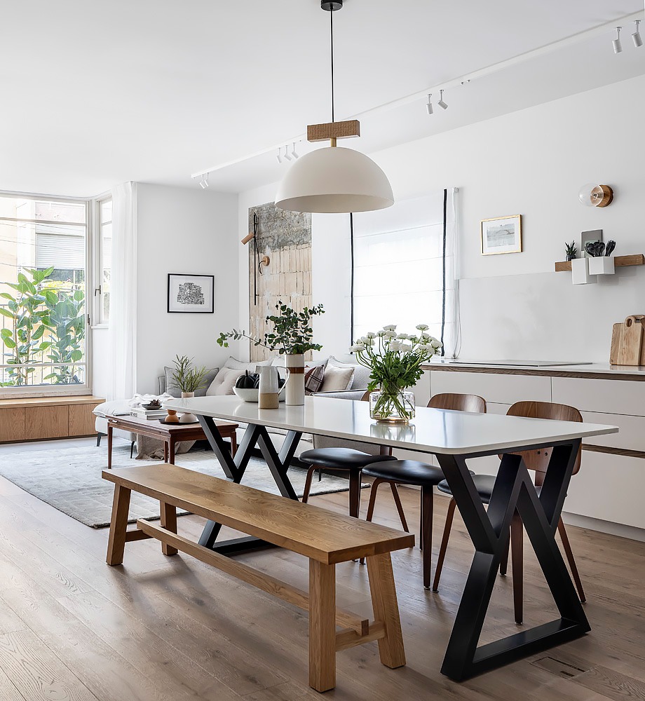 Long dining table with a wooden bench by the windows