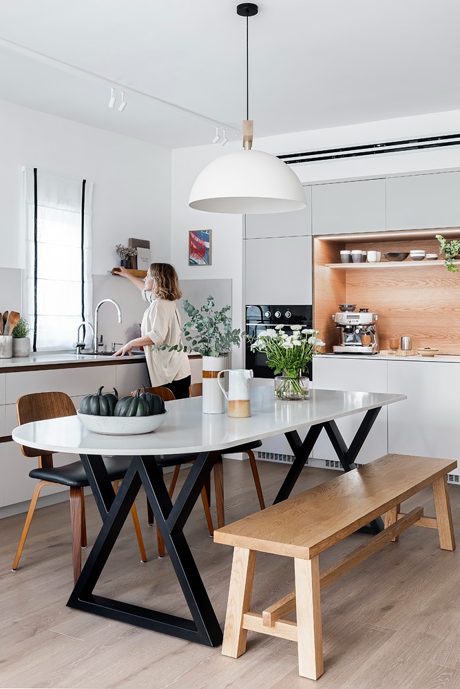 Dining table with a wooden bench and a kitchen with a wooden niche