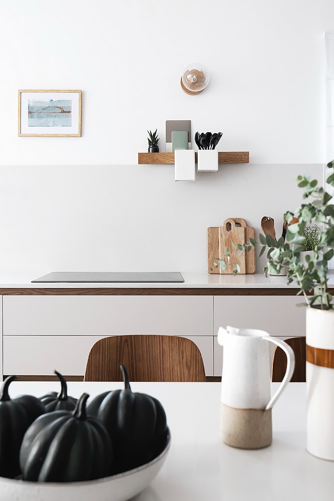 Detail: white kitchen counter with a small wooden shelf