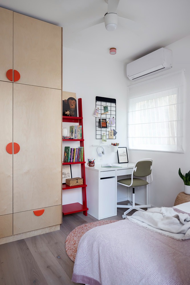 Light plywood wardrobe with round red handles and red shelves