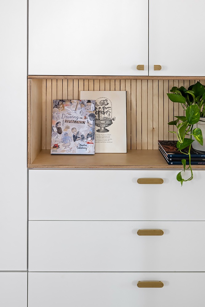 Detail: fluted wooden niche with books in a white cabinet