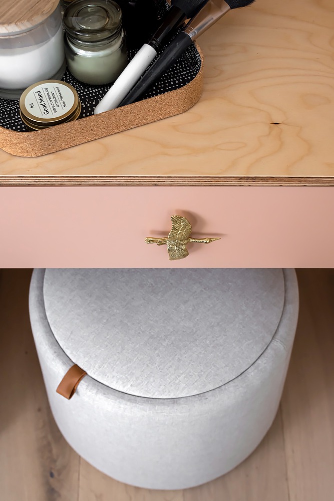 Detail: pink drawer with a brass handle and a white pouf