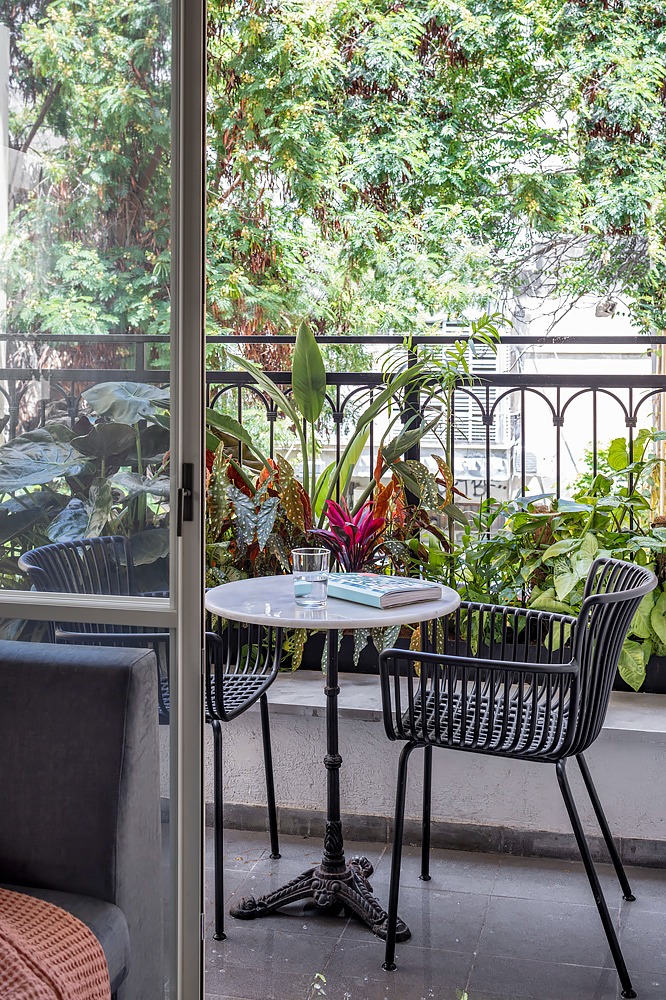 Balcony with a bistro table and lush plants