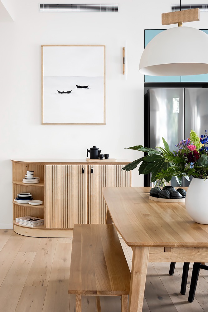 Fluted wooden sideboard and flowers by the dining table