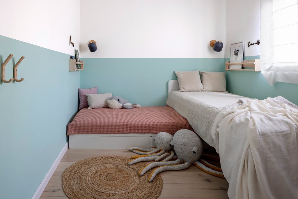Kids' room with a two-tone pale blue wall and two beds