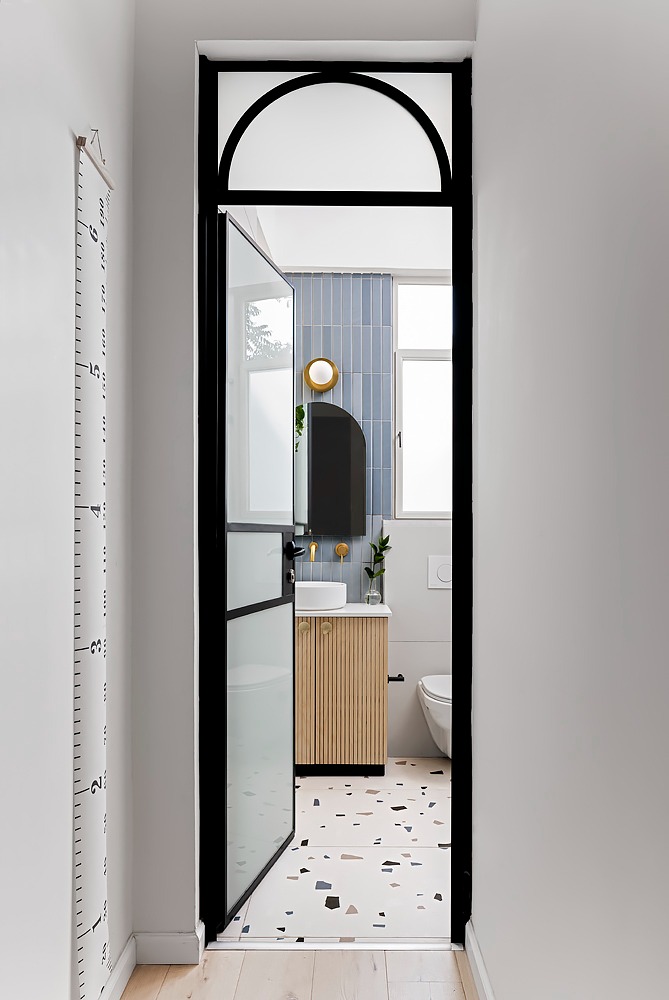 Narrow black arched door to the bathroom