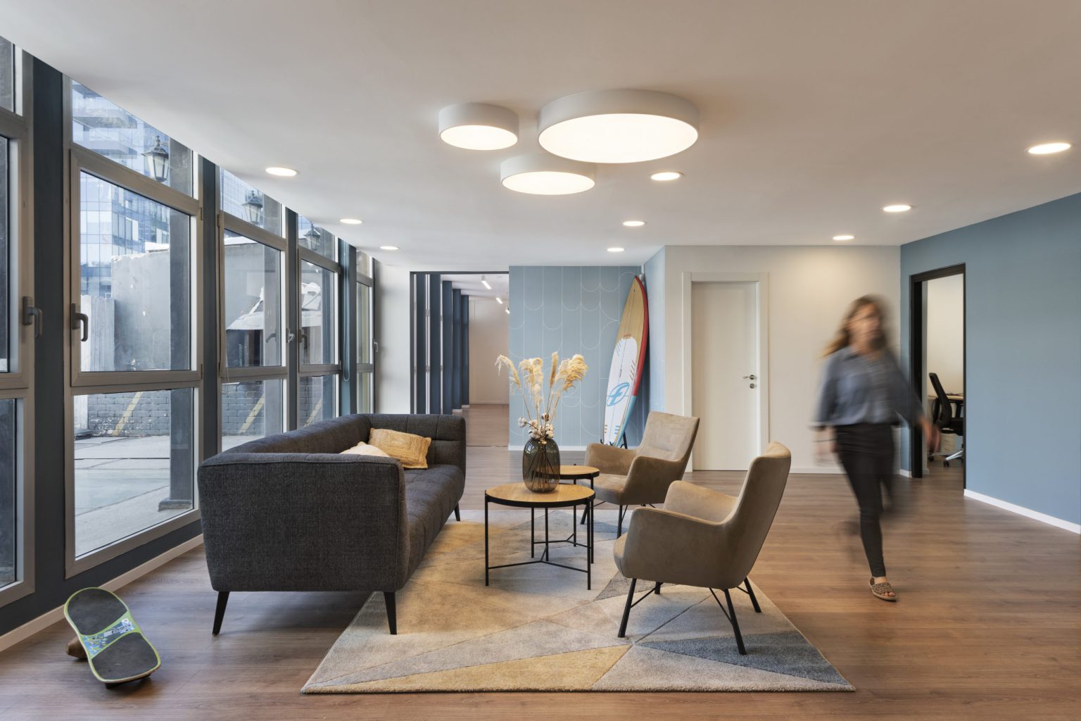 Lobby with a grey sofa and armchairs by the windows