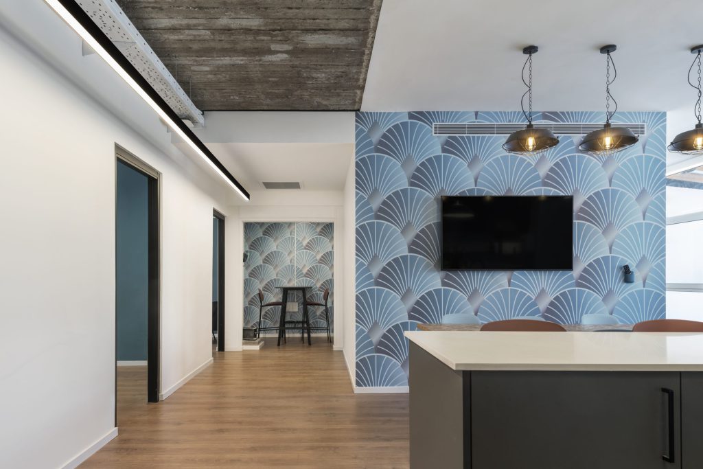 Blue fan-pattern wallpaper wall with brass pendants