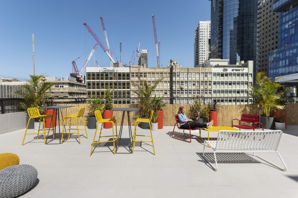Roof terrace with colourful chairs and a view of the towers