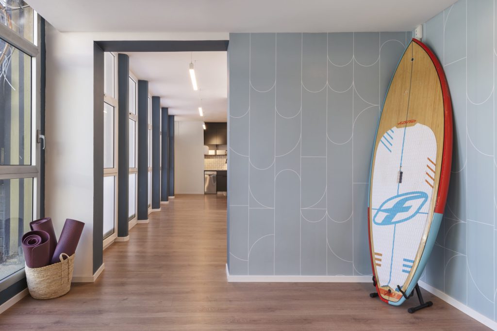 Corridor with a surfboard leaning on a blue wall