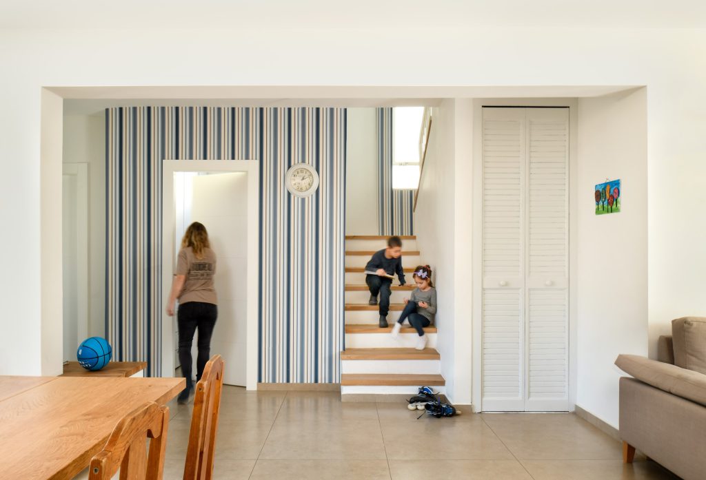 Wooden stairs and a blue-striped wall facing the dining area