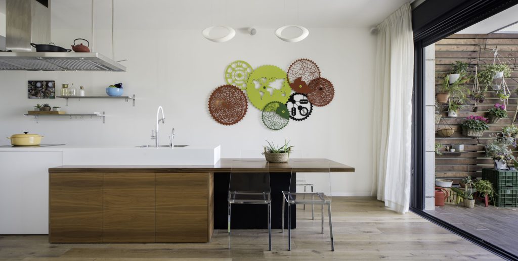 White kitchen with a wooden island and woven plates on the wall