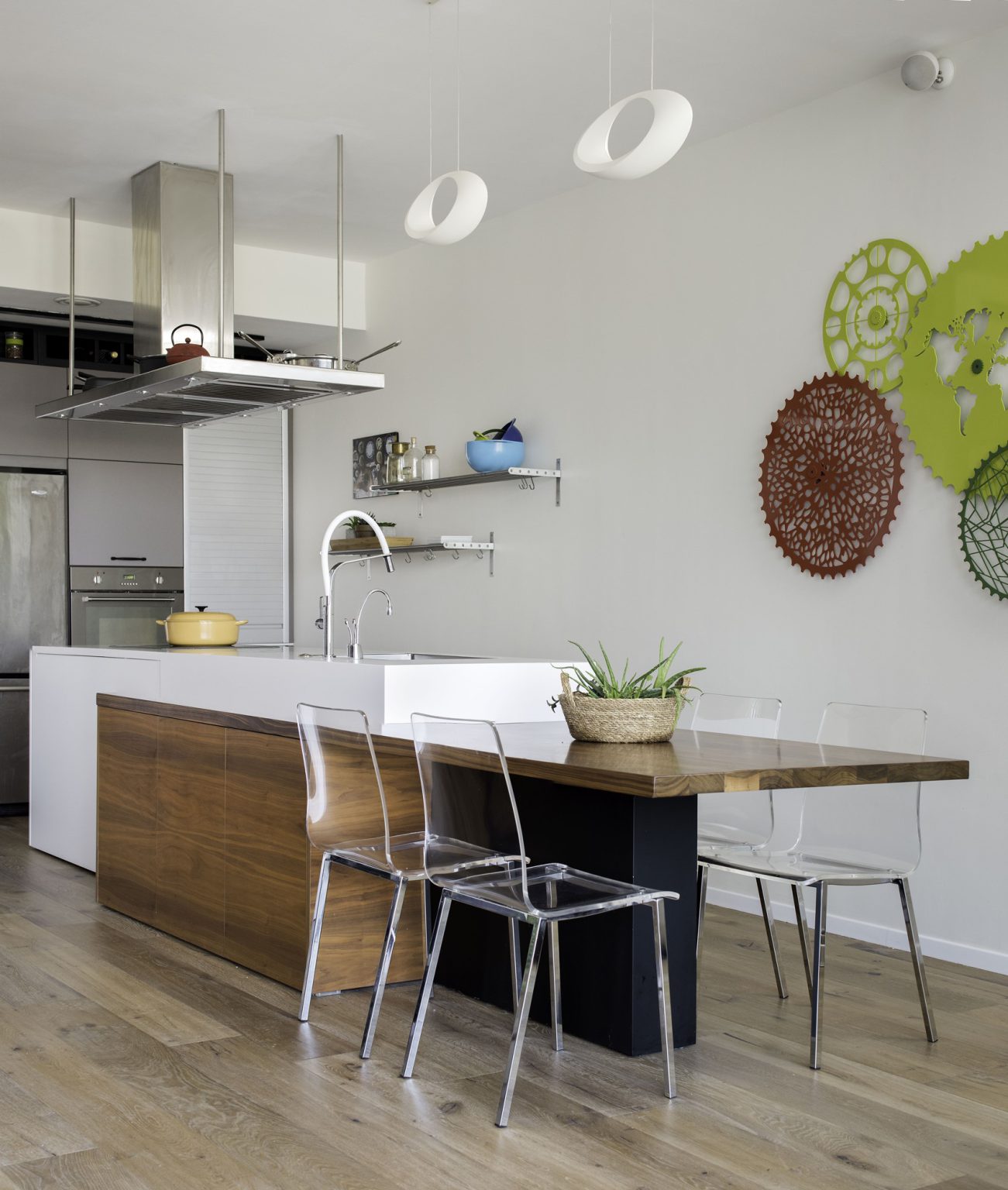 Kitchen island with a reclaimed wood table and clear chairs