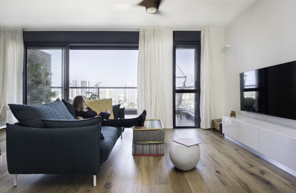 Living room with a dark blue sofa facing tower windows