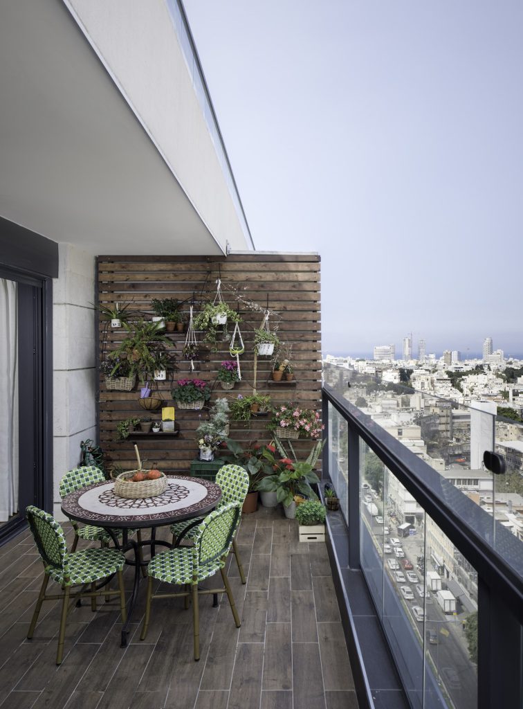 Tower balcony with a plant wall and a round mosaic table, apartment in Tel Aviv – Chen Shadmi, Shadmi Design