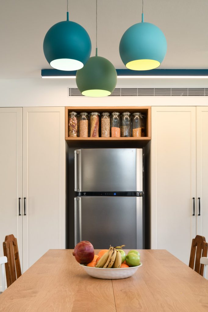 Teal pendants above the dining table facing the fridge