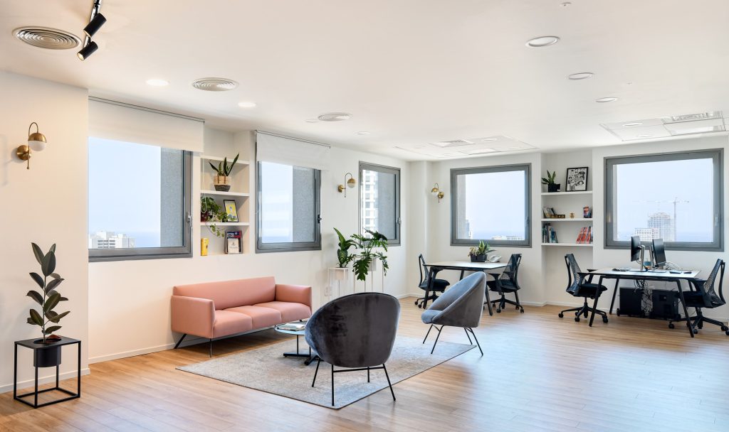 Bright open office with a pink sofa and desks