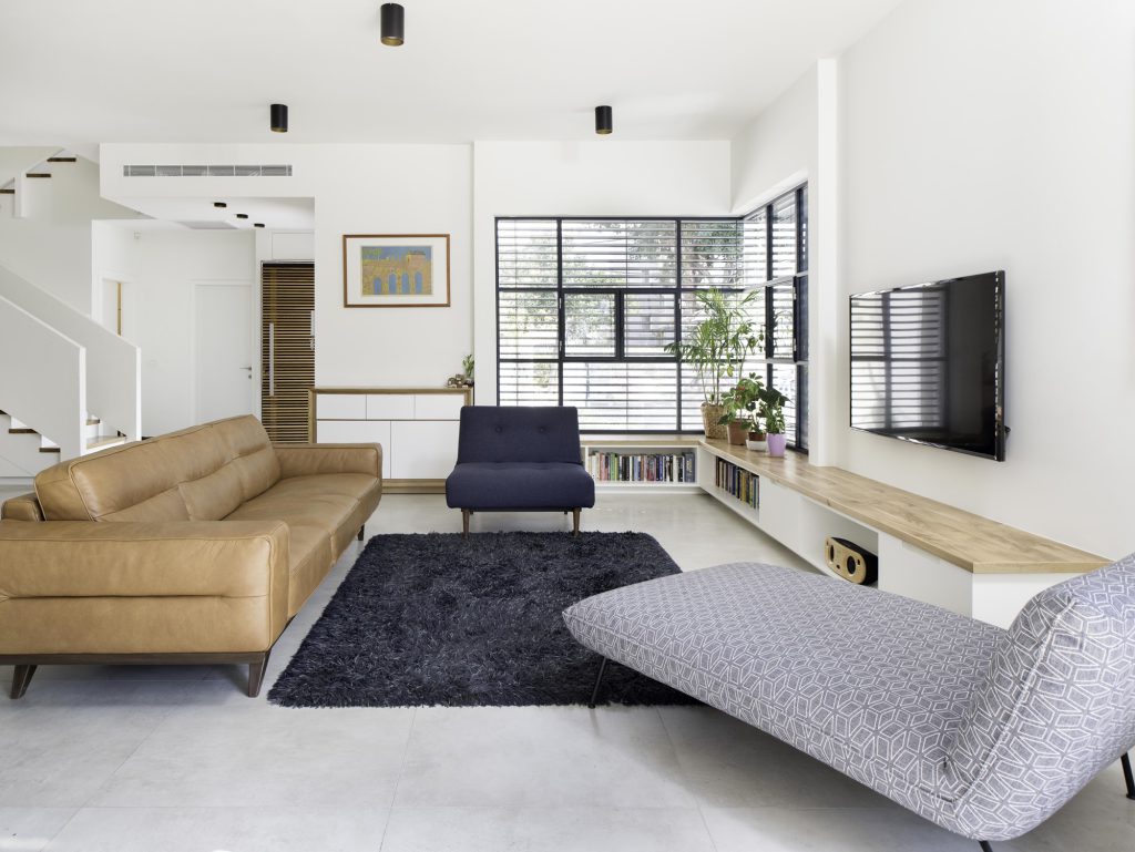 Living room with a patterned chaise and a leather sofa