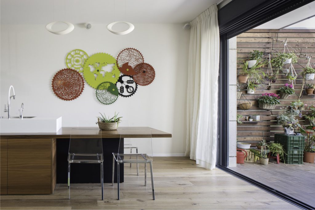 Wooden kitchen island facing the balcony plant wall