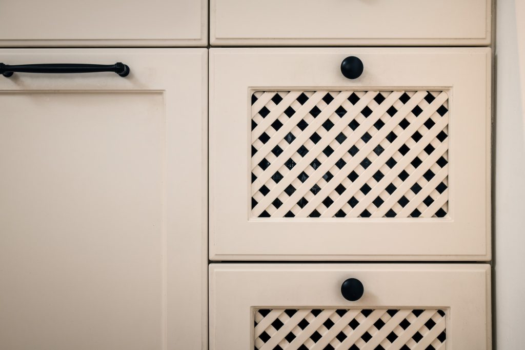 Detail: perforated cabinet front and a black handle