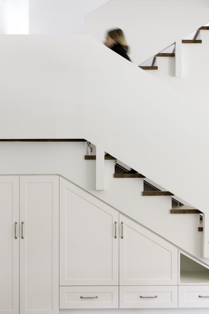 White stairs with cupboards built in below