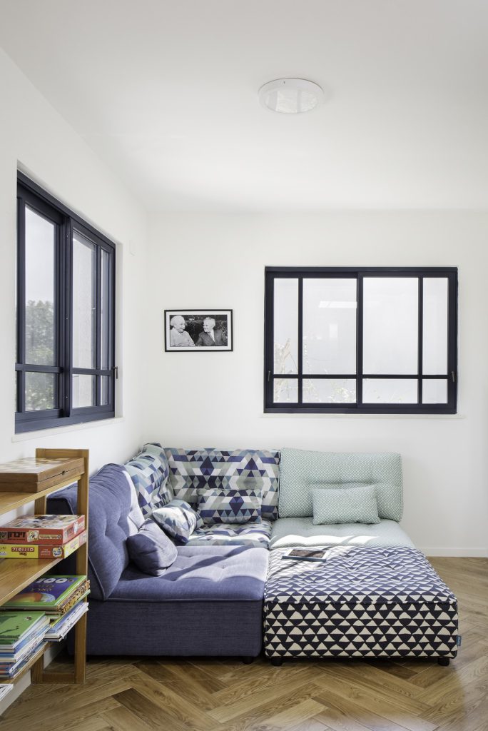 Daybed below black-framed windows