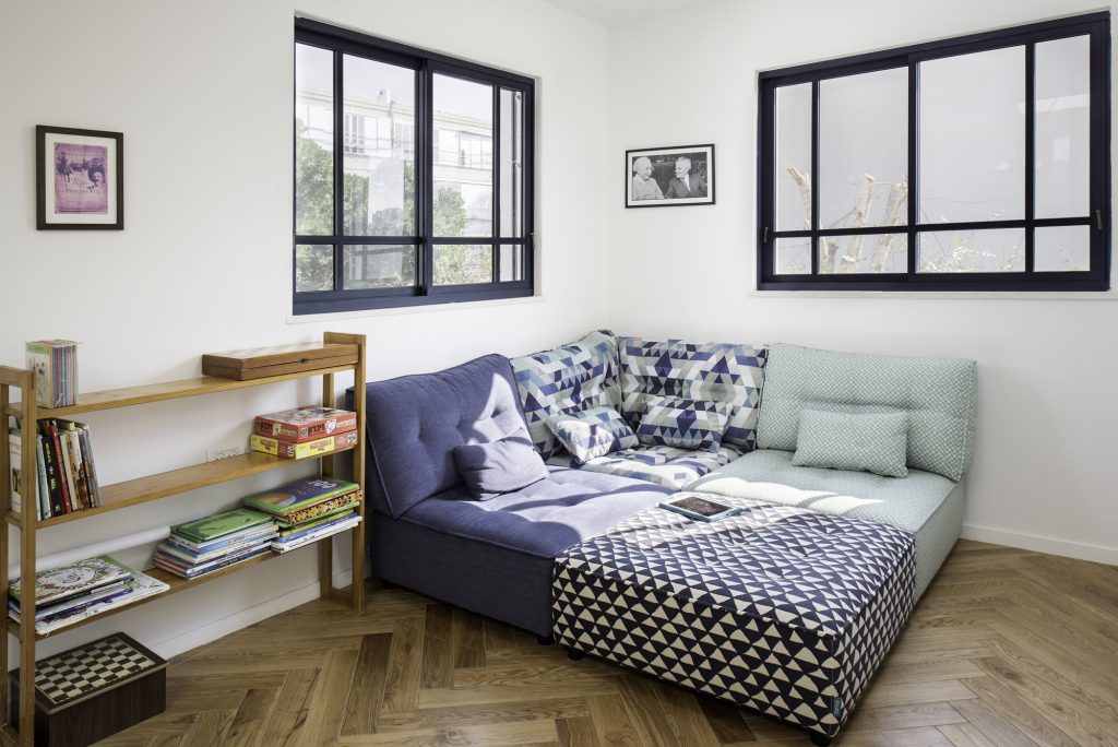 Daybed with patterned cushions and a wooden bookshelf