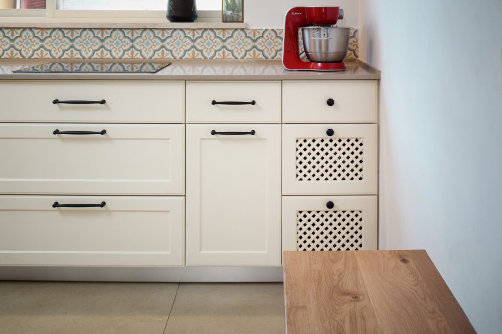 White shaker kitchen cabinets with perforated fronts