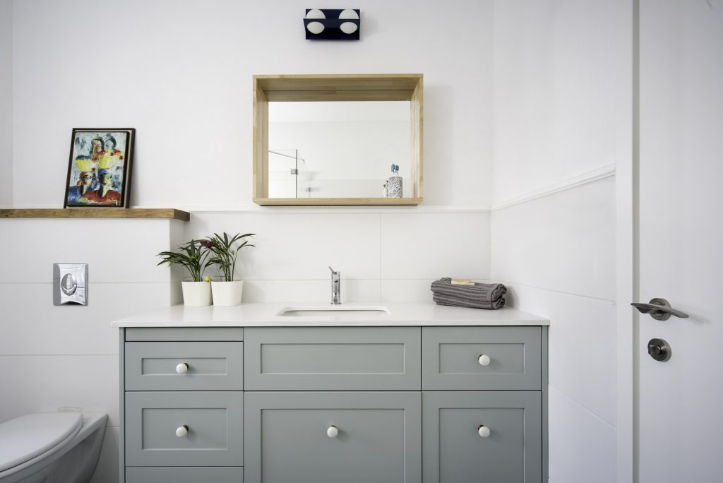 Grey shaker-style vanity and a wood-framed mirror