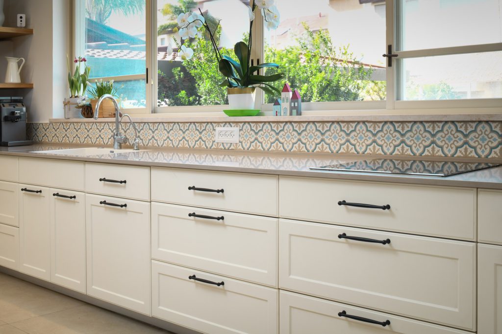 Long kitchen counter below a wide garden window