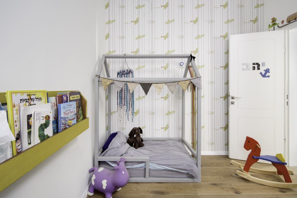 Kids' room with a house-frame bed and bird wallpaper