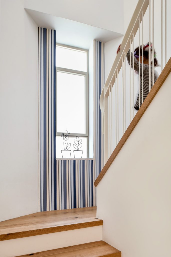 White stairs with a blue-striped wall
