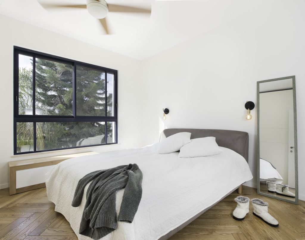 Bedroom with a wide black window and a standing mirror