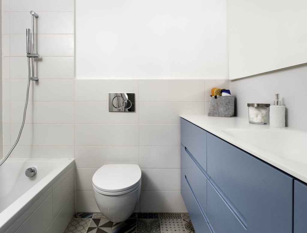Bathroom with a bathtub and a blue-grey vanity