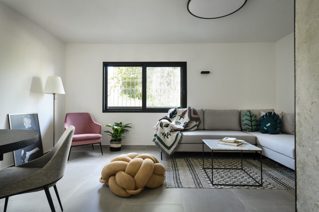 Living room with a pink armchair facing a black window