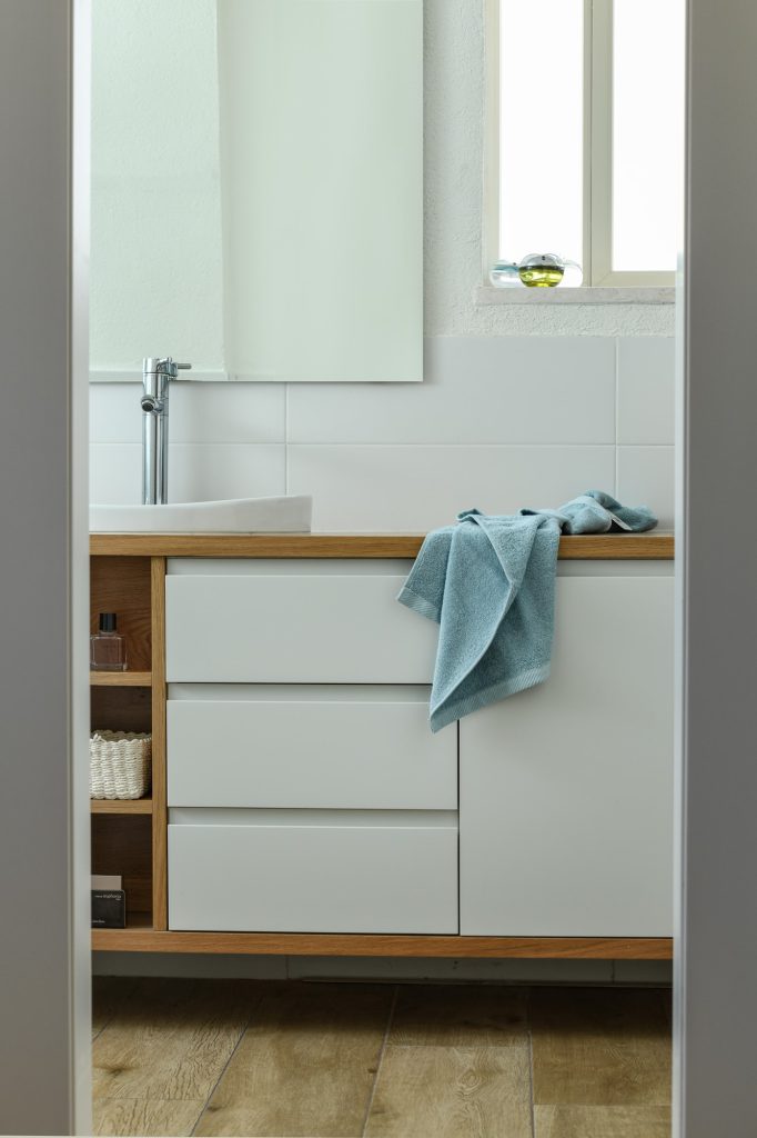White vanity with drawers and a wooden frame