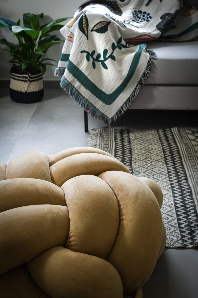 Detail: mustard knot pouf and a patterned throw