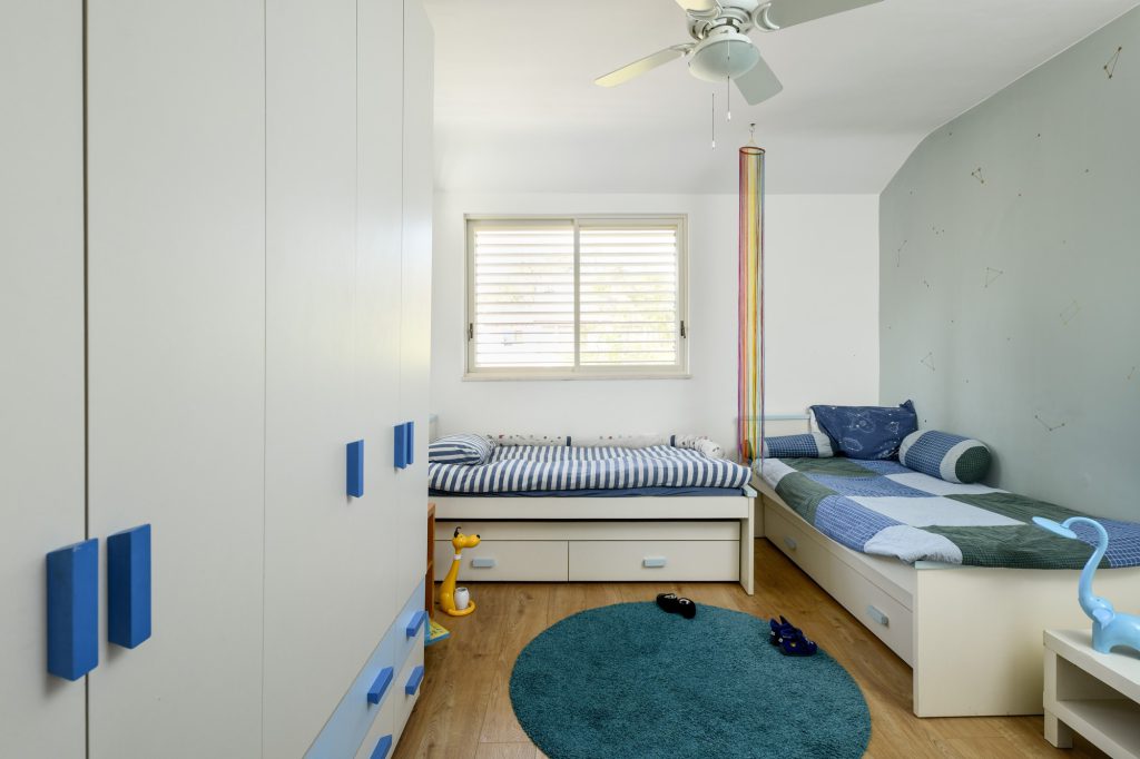 Kids' room with two beds and blue handles