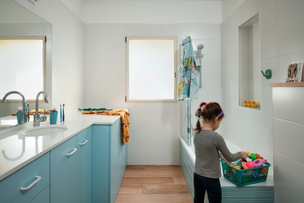 Kids' bathroom with a teal vanity